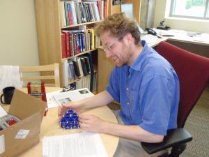 A man sitting at a desk with a model